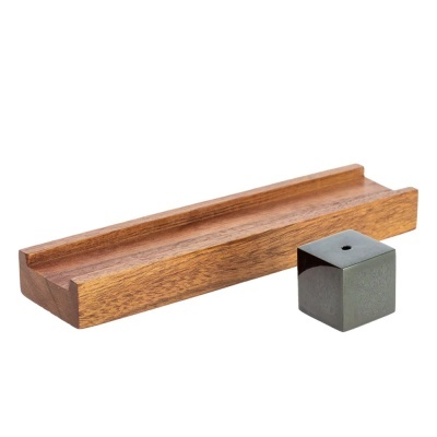 Base de madeira castanha com entalhe e cubo metálico cinzento com orifício no topo