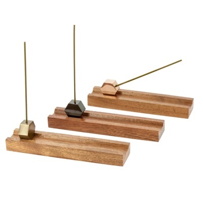 Suportes para incenso em madeira com base metálica em três cores diferentes.