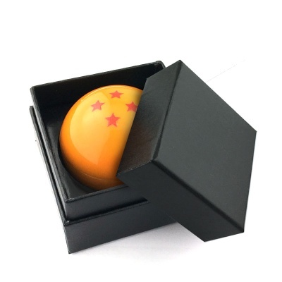 Esfera laranja com cinco estrelas vermelhas numa caixa preta aberta