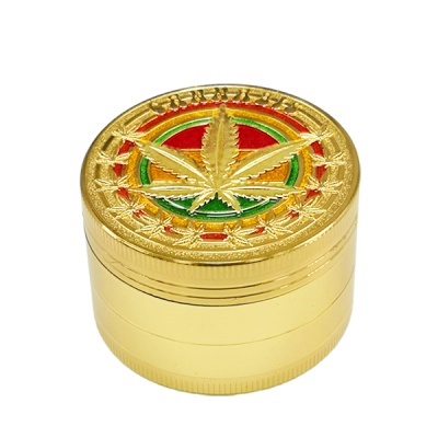 Triturador metálico dourado com folha de cannabis no topo