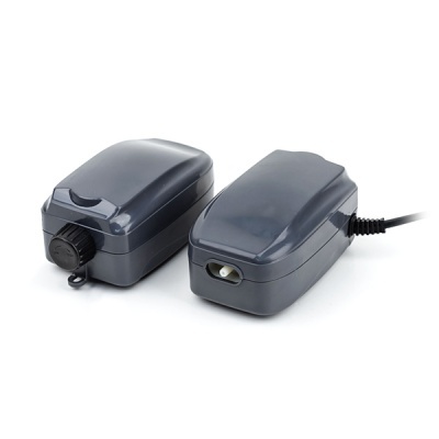 Dois compressores de ar elétricos pequenos e cinza escuro sobre fundo branco.