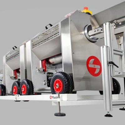 Máquina industrial metálica com rodas vermelhas e base branca