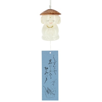 Sino de vento cerâmico com figura de criança e tira azul com caligrafia japonesa.