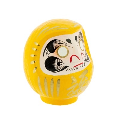 Boneco Daruma amarelo com detalhes dourados e rosto pintado