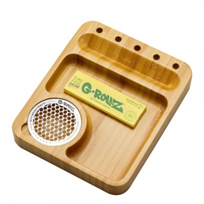 Tabuleiro de bambu com triturador de metal redondo e pacote de papel para enrolar cigarro