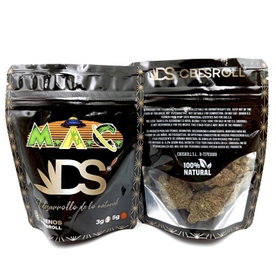 Pacote preto com texto e gráfico colorido, contendo produto natural visível através de janela transparente
