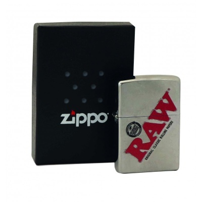 Isqueiro metálico prateado com logótipo RAW ao lado de caixa de Zippo preta