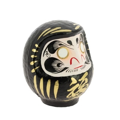 Estatueta de Daruma preta com detalhes dourados e pintura facial brancos