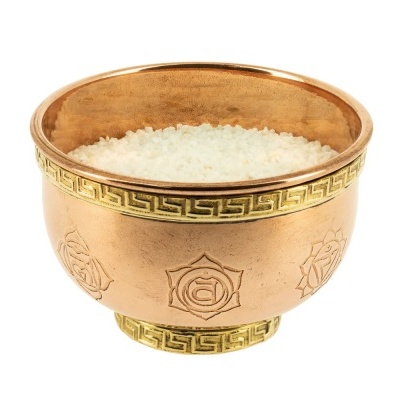 Tigela de metal dourado com sal grosso branco