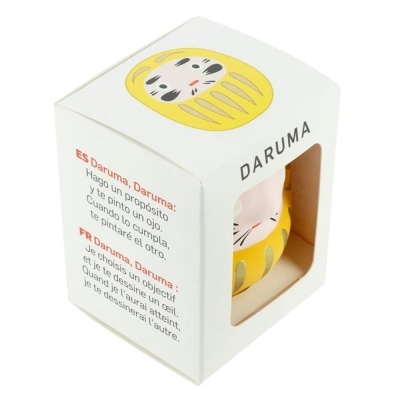 Embalagem de figura Daruma amarela com texto em espanhol e francês