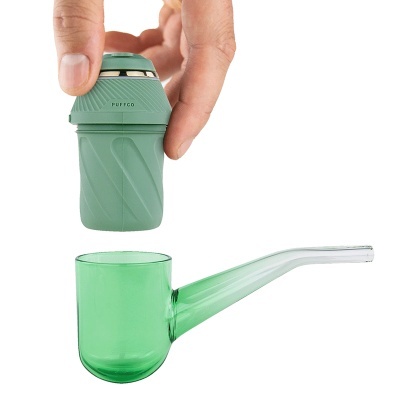 Dispositivo portátil verde a ser colocado sobre um cachimbo de vidro verde translúcido.