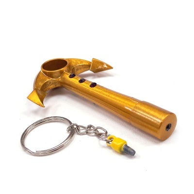 Chaveiro dourado em forma de ferramenta com anilha metálica e detalhe amarelo
