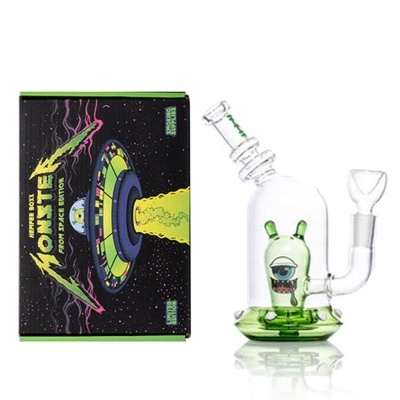 Peça de vidro transparente com monstro verde e caixa preta colorida com disco voador