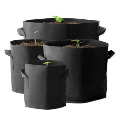 Conjunto de quatro sacos de cultivo em tecido preto com plantas pequenas