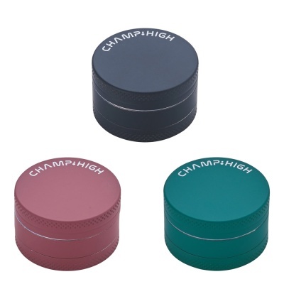 Três moedores redondos de metal coloridos com a marca CHAMP:HIGH no topo