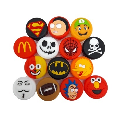 Tampas redondas com desenhos de personagens e símbolos diversos em fundo branco.