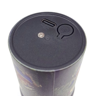 Parte superior de dispositivo cilíndrico preto com porta USB-C e botão de energia
