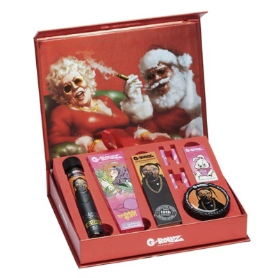 Conjunto G-ROLIZ para tabaco com embalagem vermelha ilustrada com Pai Natal fumador e mulher, contendo tubos, cones e tabuleiro decorado.