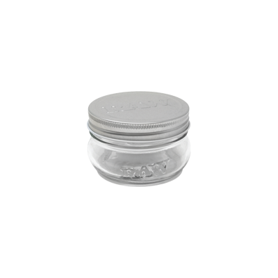 Frasco pequeno de vidro com tampa metálica prateada e texto RAW em relevo