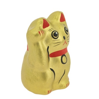 Estatueta dourada de gato com detalhes vermelhos e pretos