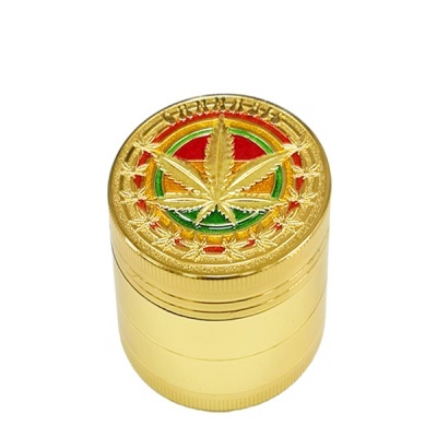 Triturador metálico dourado com folha de cannabis colorida na tampa