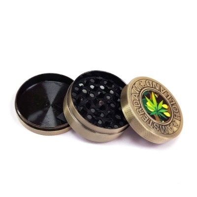 Triturador de metal bronze com tampa decorada com folha verde e texto Amsterdam Holland