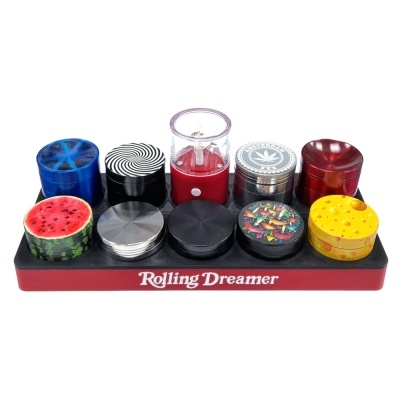 Conjunto colorido de trituradores de ervas com padrões variados num suporte com texto Rolling Dreamer