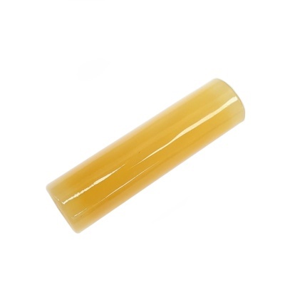 Objeto cilíndrico amarelo liso e brilhante sobre fundo branco