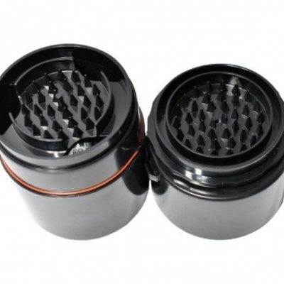 Triturador preto de erva em duas partes com dentes triangulares e junta laranja