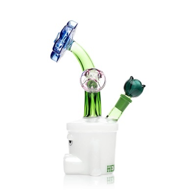Bong de vidro com base branca em forma de rosto e tubos verdes com pedras coloridas.