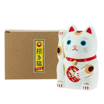 Estátua de gato Maneki-neko branco com detalhes coloridos ao lado de caixa de cartão com etiqueta japonesa