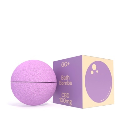 Bomba de banho rosa claro e caixa roxa e bege com texto GG+ Bath Bombs CBD 100mg