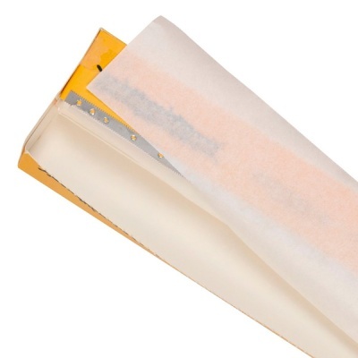 Rolo de papel vegetal branco numa caixa amarela com lâmina de serragem