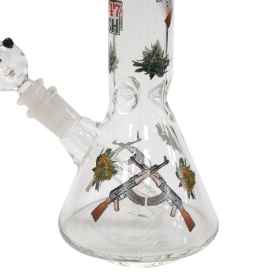 Base de vidro transparente de um cachimbo de água com imagens estampadas de armas e folhas de cannabis.