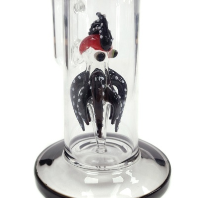 Estatueta de vidro de pássaro preto com pontos brancos e vermelho dentro de tubo de vidro.