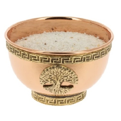Taça cobre com decoração dourada e grãos brancos no interior