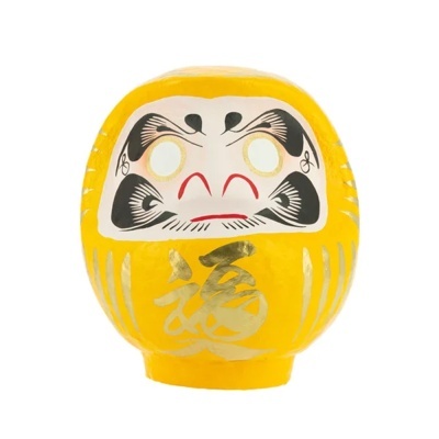 Boneco Daruma amarelo em papel machê com pintura facial e caracteres dourados