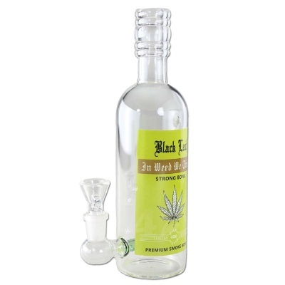Frasco de vidro com rótulo verde e tubo de vidro para fumar