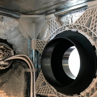 estrutura metálica com tubo preto e suportes plásticos brancos sobre fundo isolante prateado