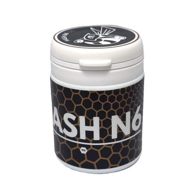 Frasco branco com rótulo preto com padrão de colmeia e texto hash n6.