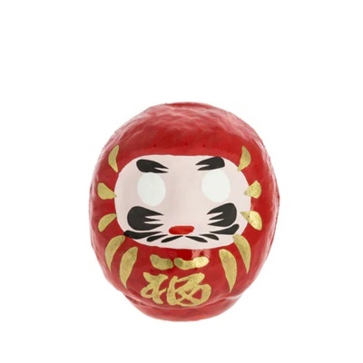 Boneco Daruma vermelho com detalhes dourados e rosto pintado