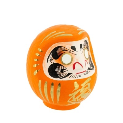 Figura Daruma laranja com padrões dourados e rosto pintado