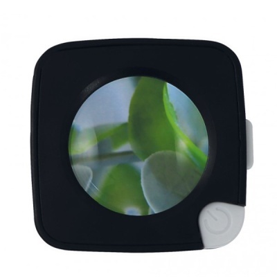 Ampliador de bolso preto com lente redonda mostrando folhas verdes