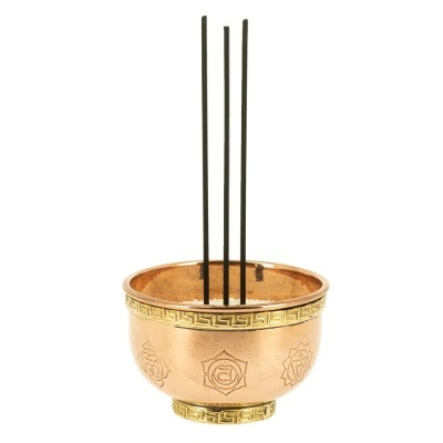 Recipiente de cobre dourado com incensos finos negros em sal branco
