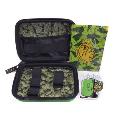 Estojo preto e verde com padrão de folhas, saco plástico verde e autocolante colorido