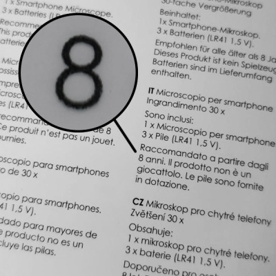 Texto multilíngue em papel com ampliação do número 8