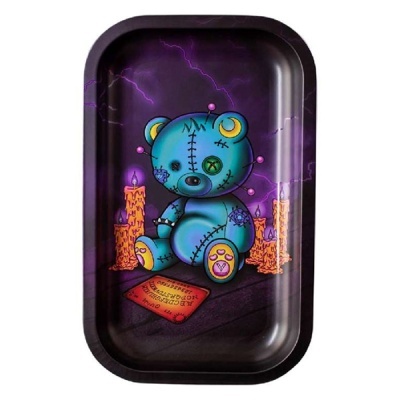 Bandeja preta com ursinho azul e velas laranja com ilustração de relâmpagos roxos