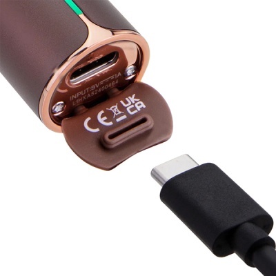 Close-up de dispositivo eletrónico castanho com porta USB-C e cabo USB-C preto