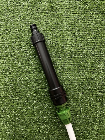 Aspersor de irrigação preto e verde sobre relva artificial