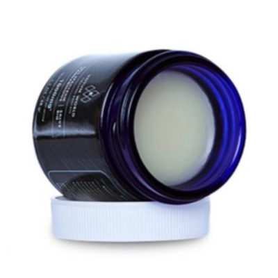 Recipiente de vidro azul com creme branco e tampa branca